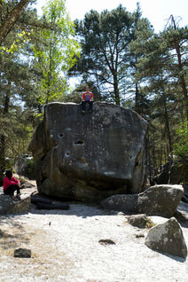 Sitting on the top of a massive boulder in Fontainebleau