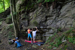 Two climbers sharing beta for a dyno style boulder problem in Avalonia